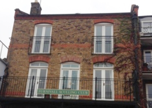 2 storey brick house with 4 large windows that have balcony cover